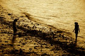 Two people standing on seashore